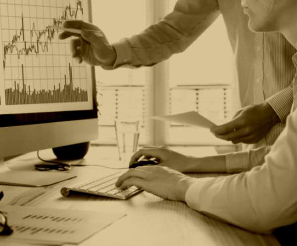 Team analyzing financial charts on a desktop, representing investment opportunities backed by research
