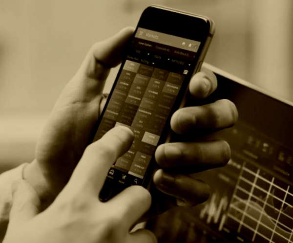 Image of a person using a smartphone showing a financial app interface